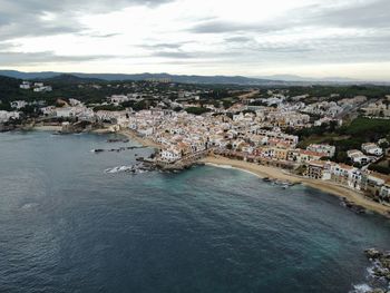 High angle view of townscape by sea against sky