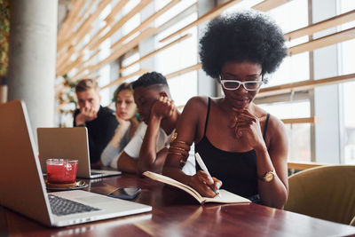 Black woman sitting in front of group of multi ethnic people 