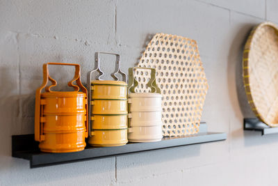 Close-up of jars on table against wall