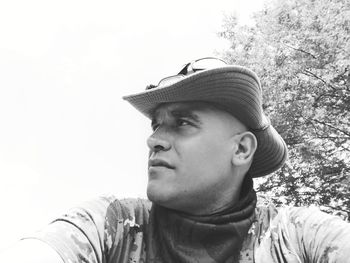 Portrait of young man looking away against sky