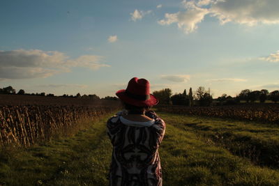 Rear view of woman standing on grassy field