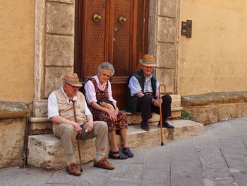 Friends sitting on wall outdoors