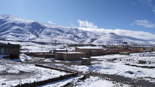 Snow covered buildings against sky