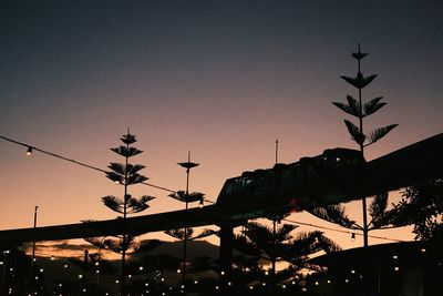 Low angle view of illuminated street light against sky at dusk