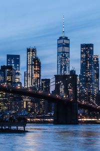 Illuminated freedom tower over brooklyn  beidge at dusk.