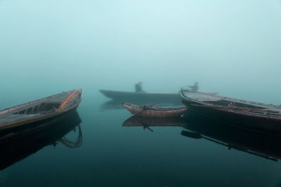 Boats moored in lake against sky