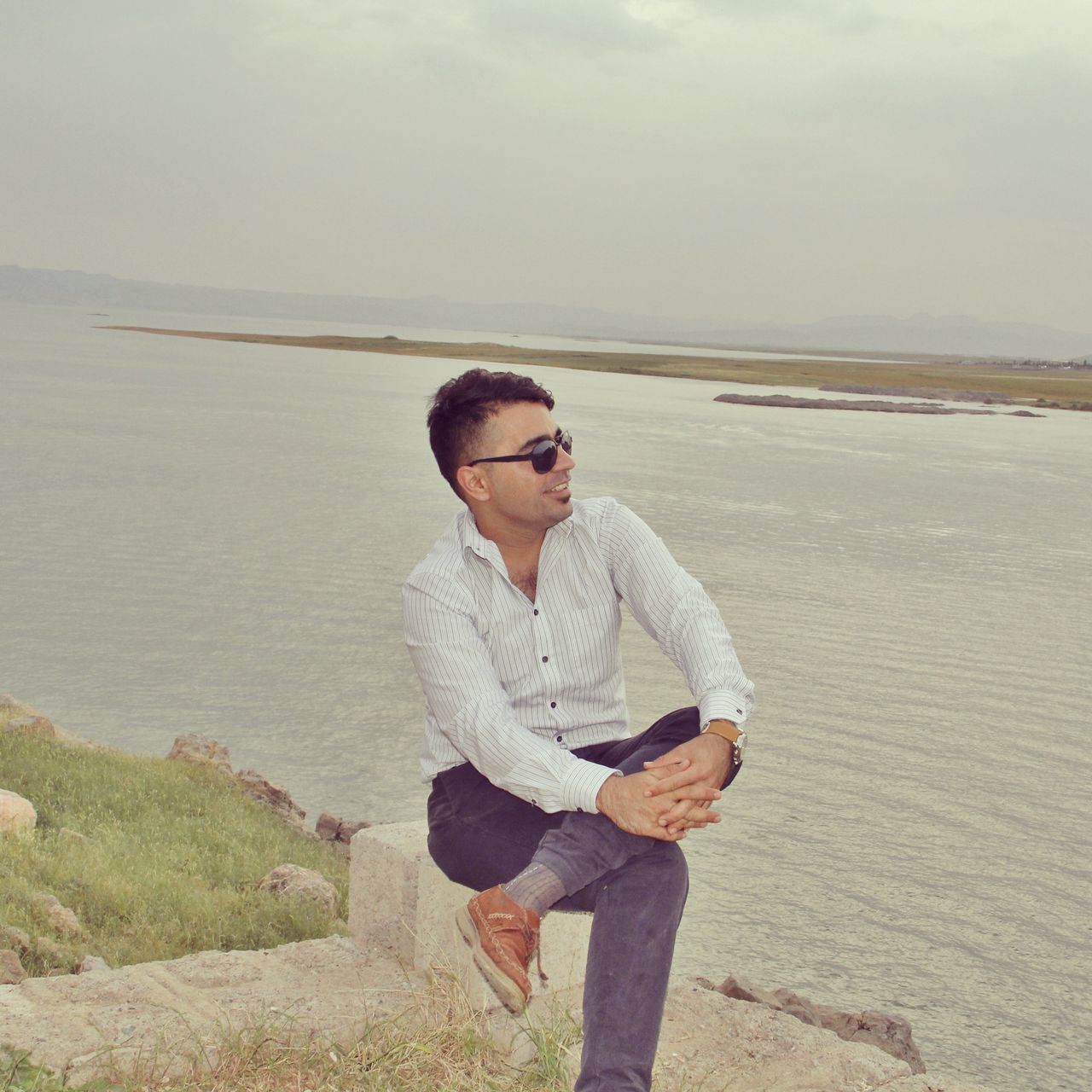 water, sea, leisure activity, casual clothing, lifestyles, person, horizon over water, full length, three quarter length, standing, sunglasses, young adult, scenics, sky, vacations, nature, tranquil scene, beauty in nature, shore, tranquility, outdoors, day, non-urban scene, summer, remote