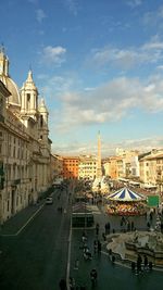 View of city street against cloudy sky