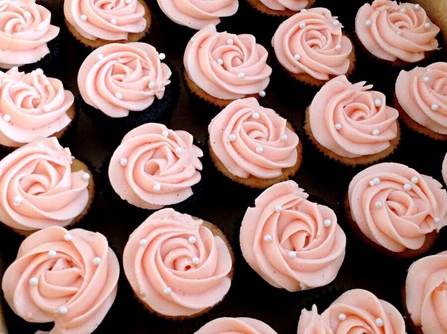 HIGH ANGLE VIEW OF CUPCAKES ON PINK ROSES