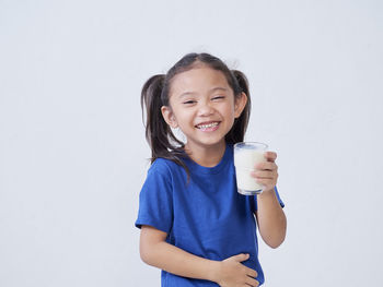 Portrait of smiling boy standing against white background