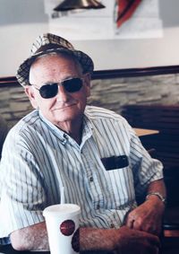 Portrait of man wearing sunglasses sitting on table