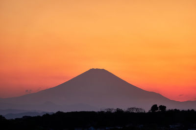 Scenic view of silhouette mountains against romantic sky at sunset