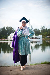 Full length of woman standing by lake