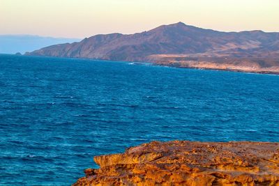 Scenic view of sea and mountains against sky