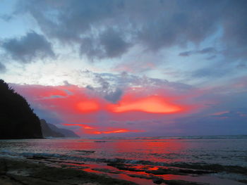 Scenic view of sea against dramatic sky during sunset