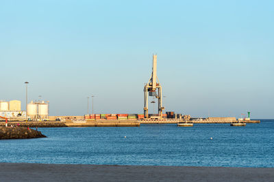 Tower by sea against clear sky