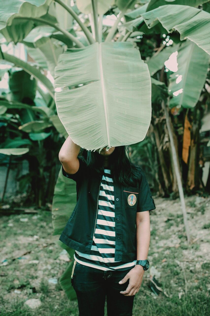 one person, real people, casual clothing, holding, standing, three quarter length, day, leisure activity, land, lifestyles, focus on foreground, plant, field, nature, front view, women, obscured face, child, outdoors