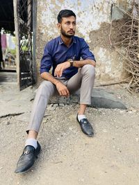 Portrait of young man sitting in city