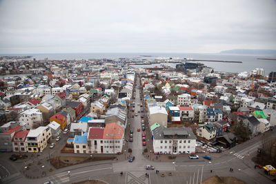 High angle view of townscape by sea against sky