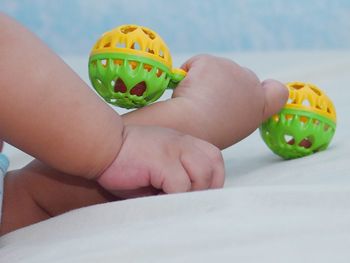 Hand of baby holding toy at home