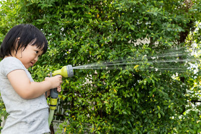 Side view of girl standing by plants