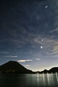 Scenic view of lake against sky at night