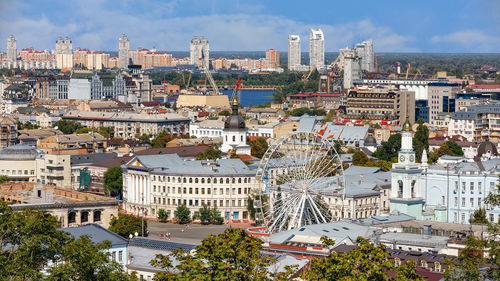 The landscape of the summer city of kyiv overlooking the old district of podil with a ferris wheel. 