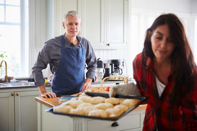 Young man and woman standing in kitchen at home