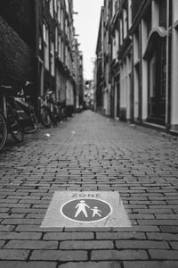 Text on footpath amidst buildings in city
