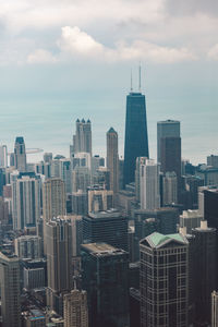 Modern buildings in city against cloudy sky