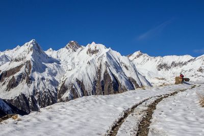 Scenic view of snow covered mountains against blue sky