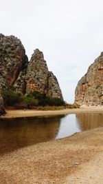 Rock formation on beach against sky