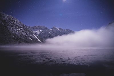 Scenic view of lake against sky at night