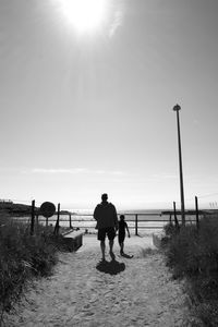 Rear view of people walking on beach