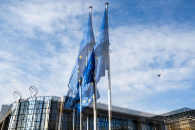 Low angle view of flag on building against sky