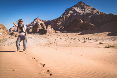 Full length of woman posing in desert at wadi rum