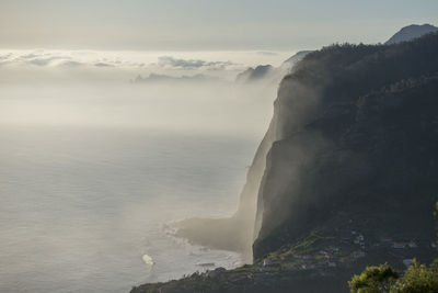 Scenic view of sea and mountains against sky