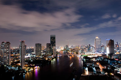 Illuminated buildings in city against sky at night