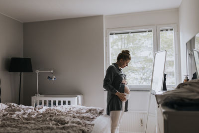 Pregnant woman looking in mirror