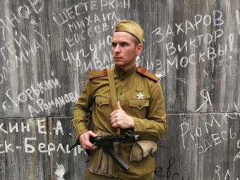 Portrait of man standing against wall