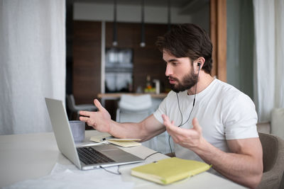 Bearded man speaking with client online