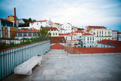 Street amidst houses in town against sky