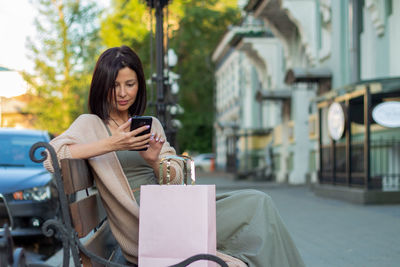 Young woman using mobile phone in city