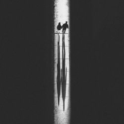 Couple walking along long straight road in dark