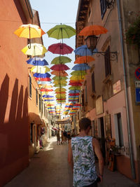 Rear view of person walking in alley way