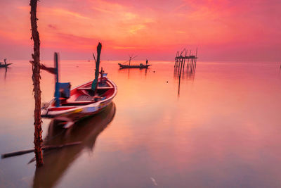 Sailboats in sea against sky during sunset