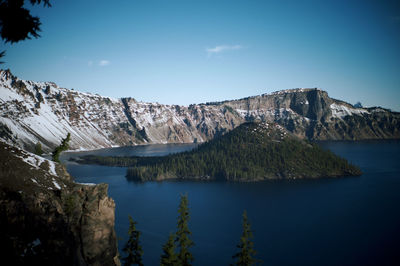 Scenic view of lake and mountains against blue sky