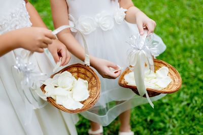 Midsection of woman holding white flowers