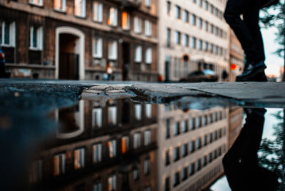 Reflection of building on puddle in city