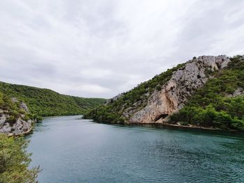 Scenic view of river amidst mountains against sky